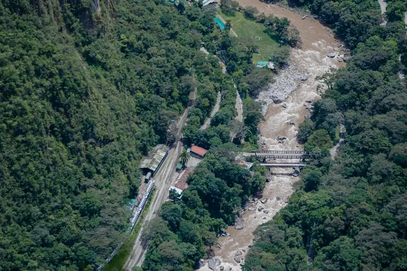 El tren junto al río Urubamba, visto desde lo alto entre montañas cubiertas de bosque